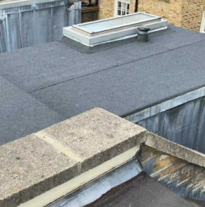 Flat rooftop with small chimney and skylight.