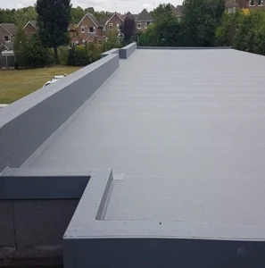 Flat grey roof with surrounding greenery.