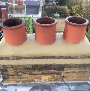 Three red chimney pots on rooftop.
